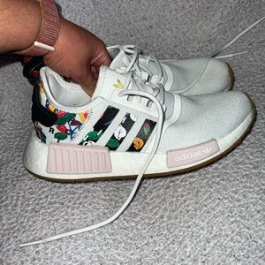 White ADIDAS exercise shoes with floral accents. Made from recycled material.